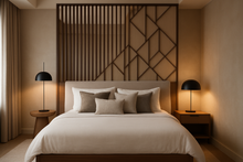 Modern bedroom with a large bed, decorative pillows, and a stylish wall partition.